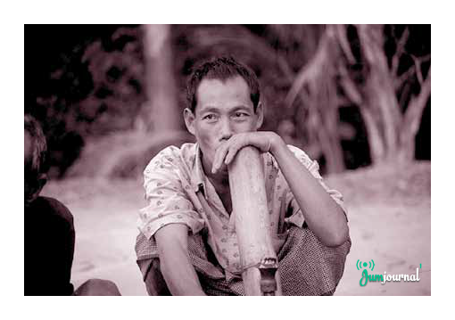 ঐতিহ্যবাহী দাবায় (বাঁশের তৈরি হুক্কা বিশেষ) তামাক সেবনরত চাকমা ব্যক্তি