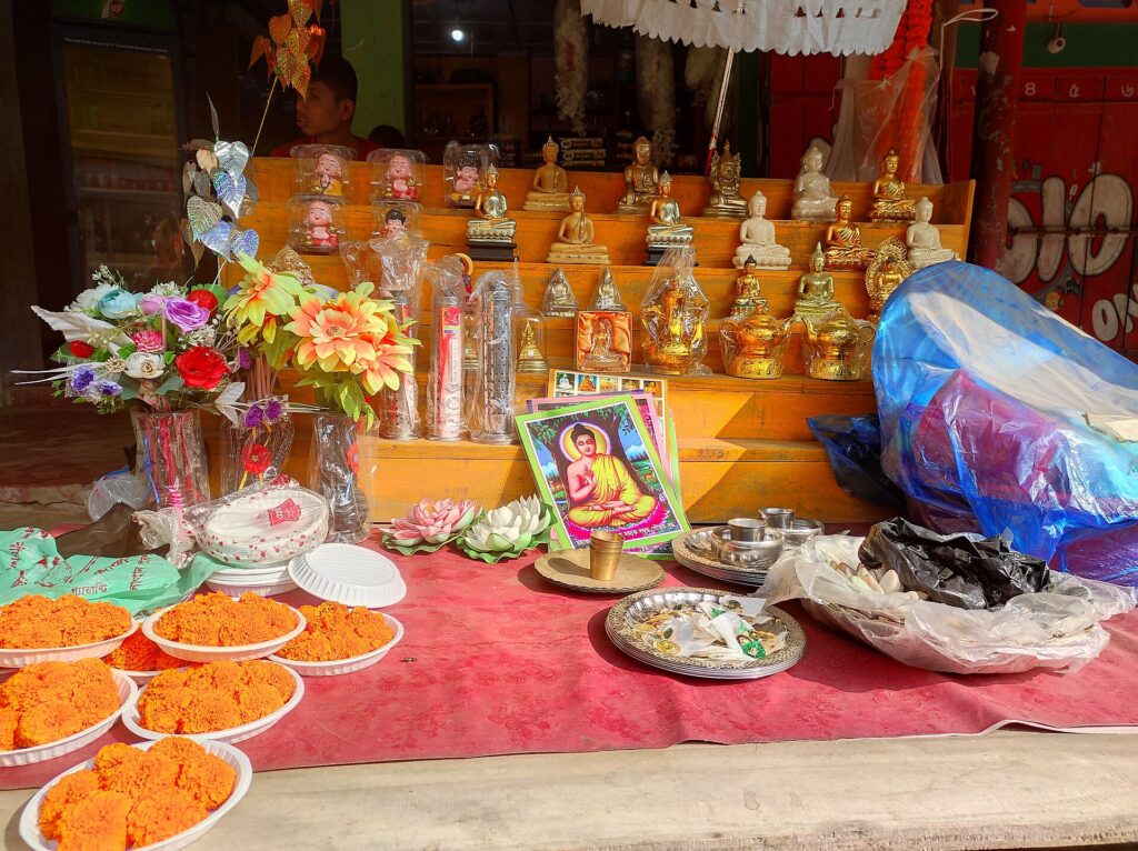 মন্দিরের ভিতরে সাজানো থালায় হলুদ ফুল, মোমবাতি ও নৈবেদ্য, পিছনে সোনালি মূর্তি