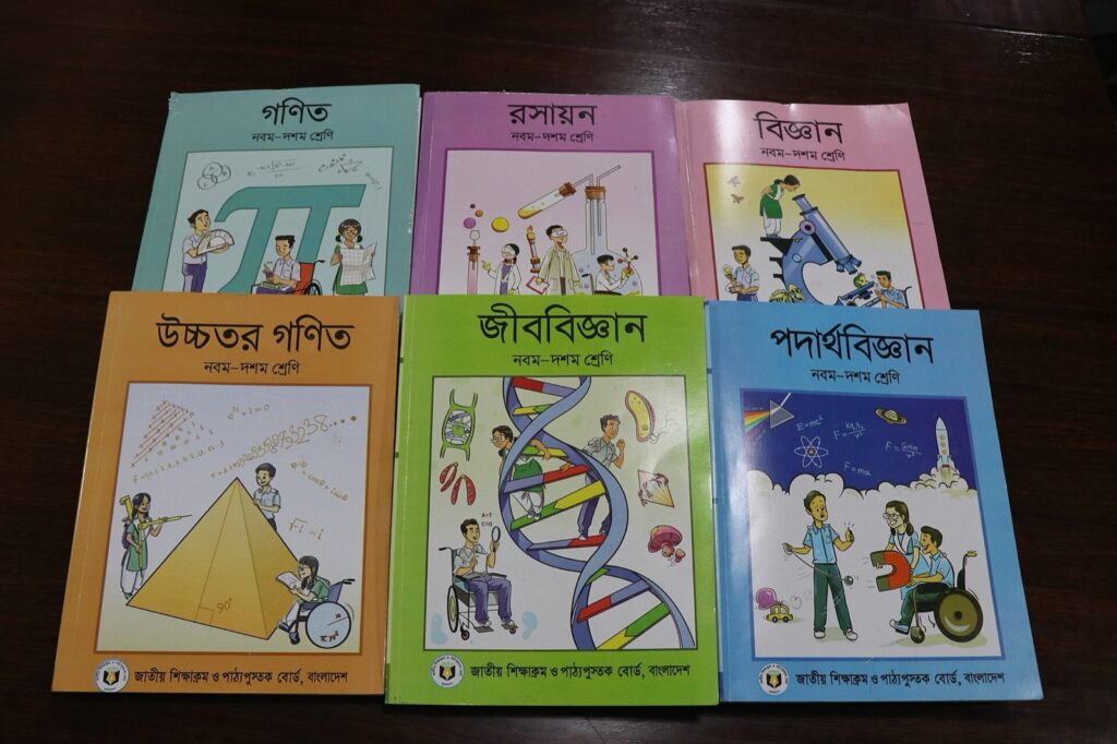টেবিলে সাজানো নবম-দশম শ্রেণির ছয়টি পাঠ্যবই — গণিত, রসায়ন, বিজ্ঞান, উচ্চতর গণিত, জীববিজ্ঞান ও পদার্থবিজ্ঞান; প্রতিটির নিচে জাতীয় শিক্ষাক্রম ও পাঠ্যপুস্তক বোর্ডের নাম