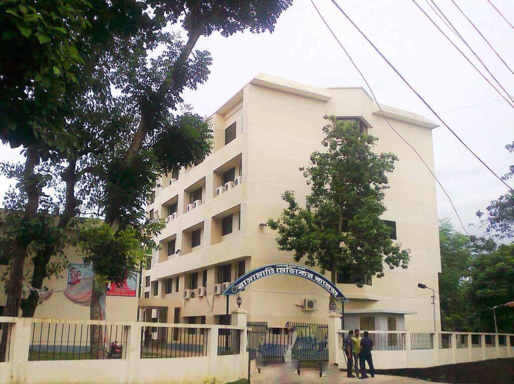 রাঙামাটি মেডিকেল কলেজের পাঁচতলা একাডেমিক ভবন, সামনে নাম লেখা তোরণ, সীমানাপ্রাচীর ও গাছপালা