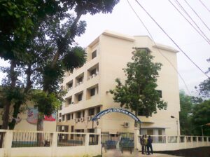 রাঙামাটি মেডিকেল কলেজের পাঁচতলা একাডেমিক ভবন, সামনে নাম লেখা তোরণ, সীমানাপ্রাচীর ও গাছপালা