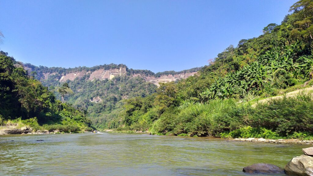 থানচির তিন্দুতে সাঙ্গু নদী, দুই পাড়ে ঘন সবুজ পাহাড় আর দূরে খাড়া পাথুরে ঢাল
